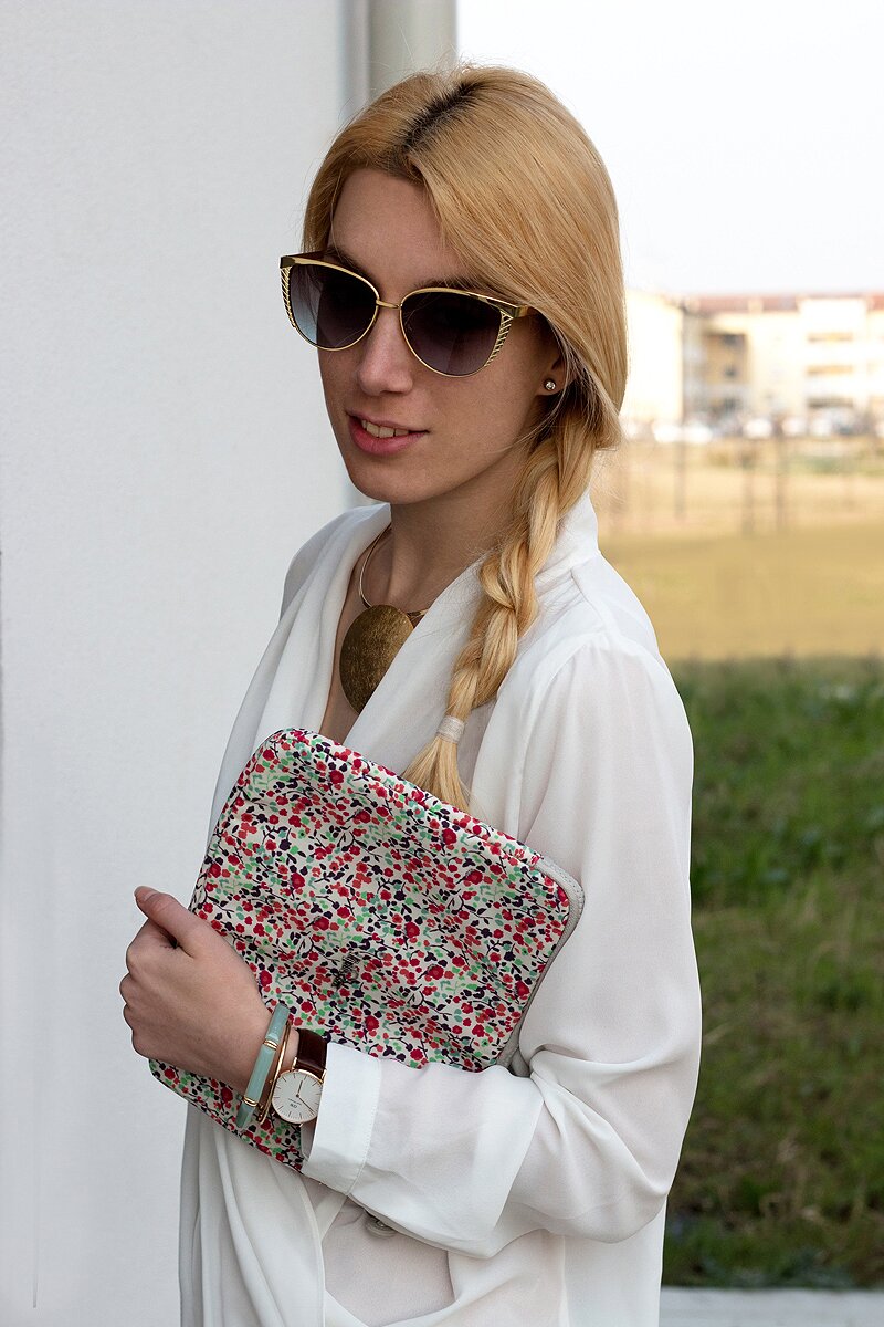 Fashion blogger Aurora Berill wearing a white cross top and Kipling floral iPad sleeve