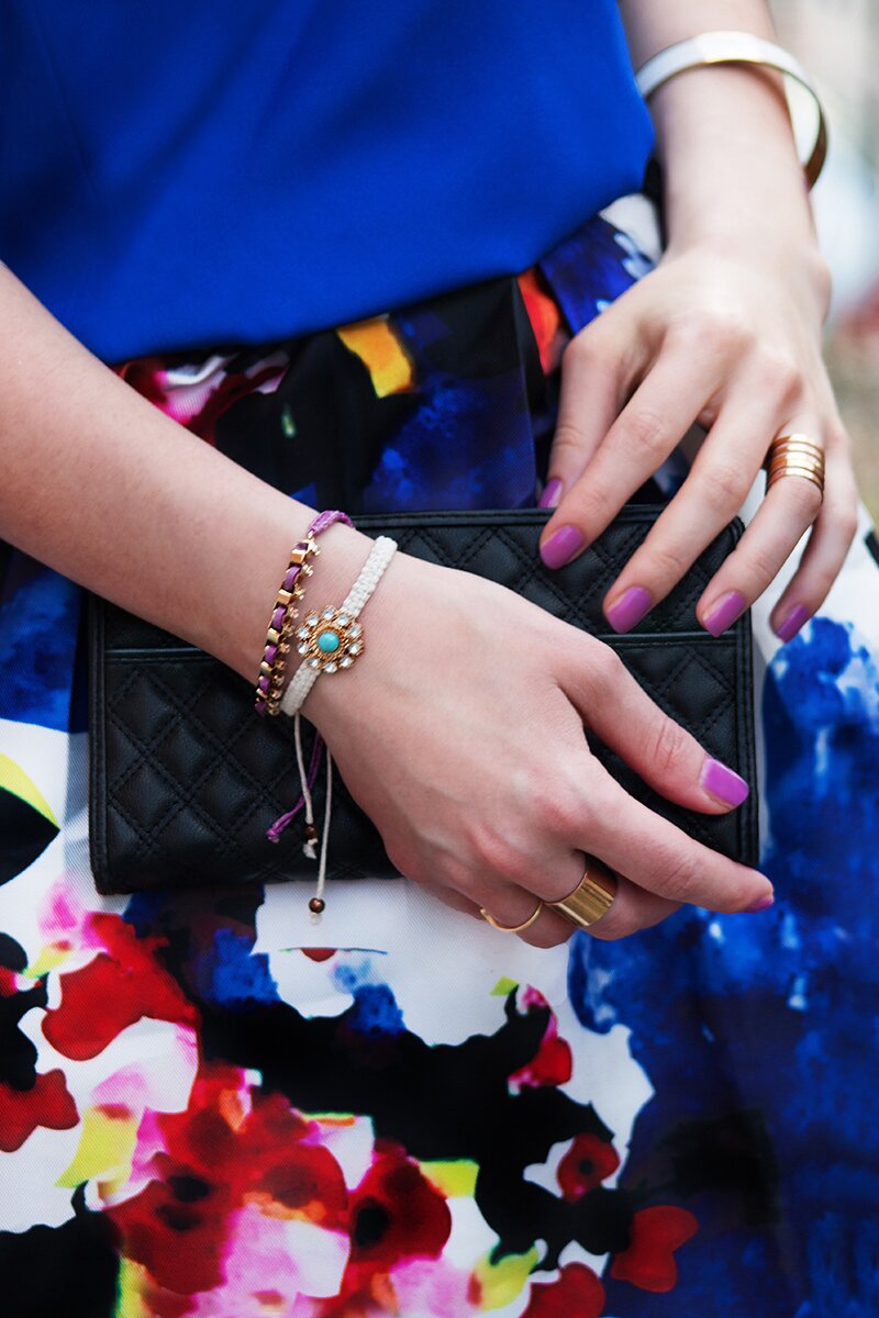 Fashion blogger Aurora Berill holding a Mango wallet and wearing a gold wishbone ring