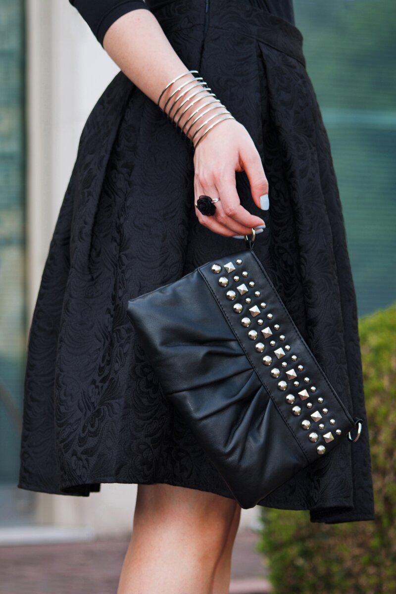 Fashion blogger Aurora Berill on a cocktail attire look wearing a jacquard midi skirt, a black studded clutch and a silver cuff bracelet