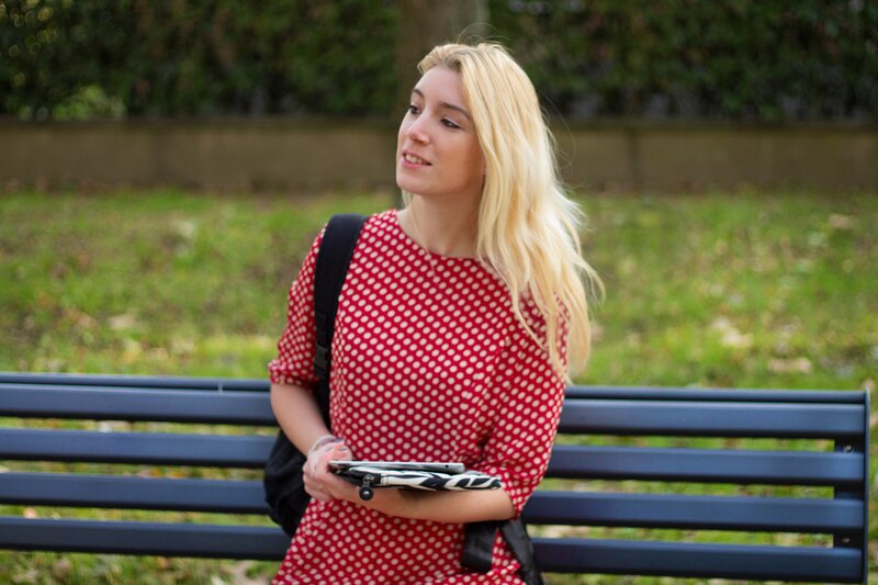 Fashion blogger Aurora Berill holding a Kipling zebra iPad case and wearing a Poppy Lux Evette fit and flare dress