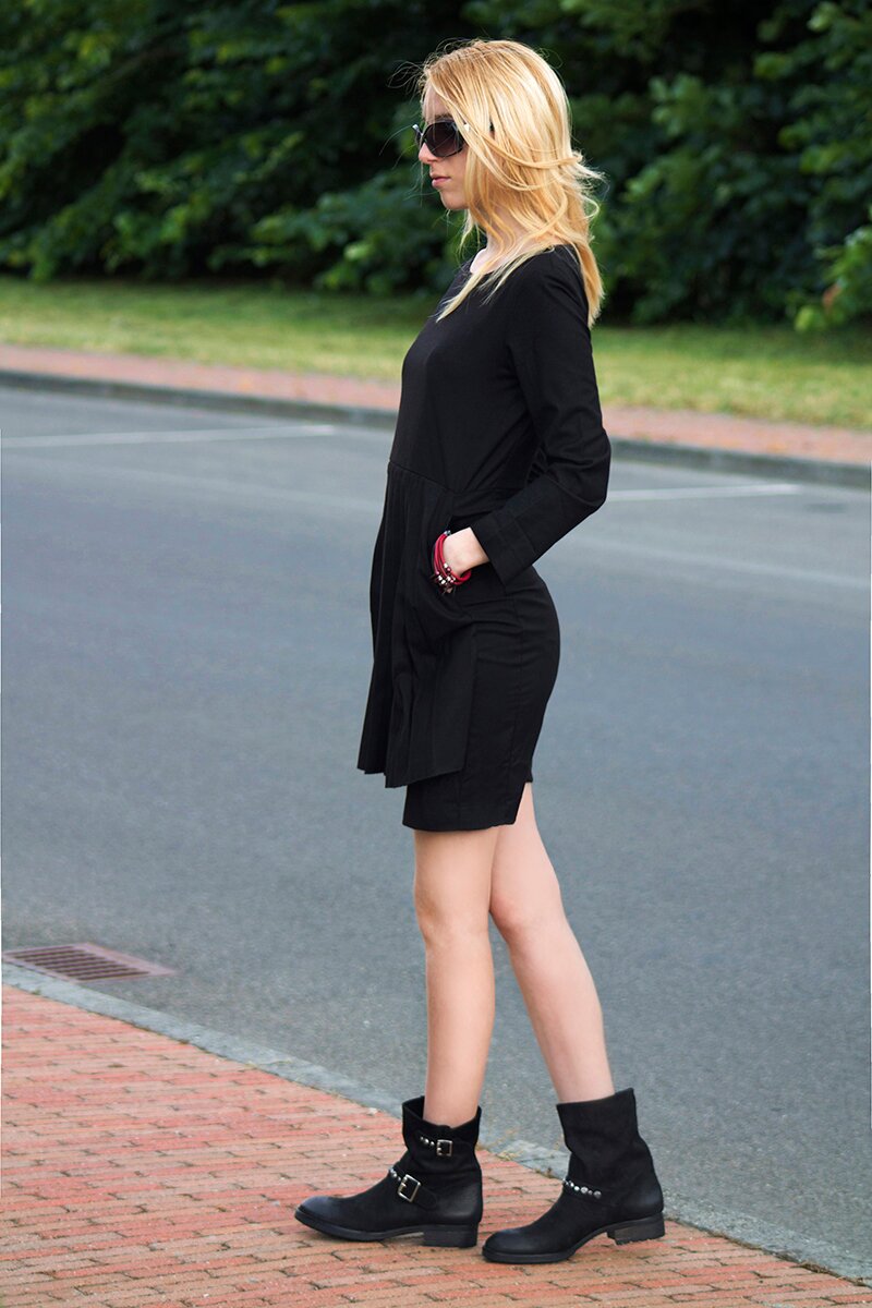 Fashion blogger Aurora Berill wearing a black pleated dress for festival outfit ideas