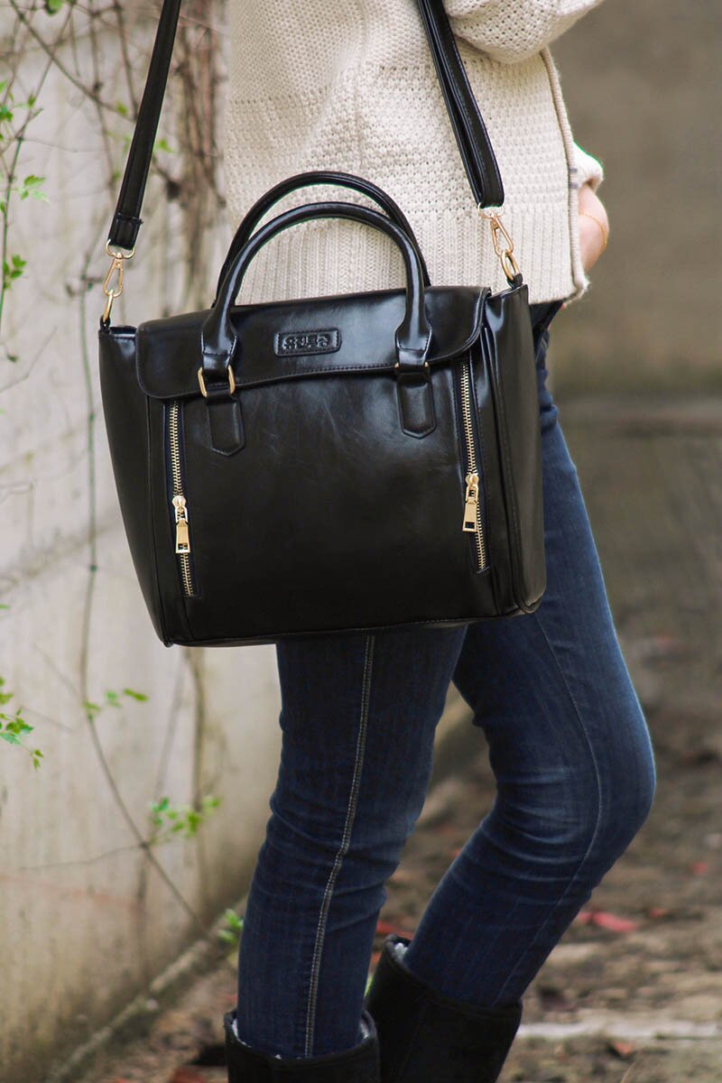 Fashion blogger Aurora Berill wearing a black trapeze bag with UGG boots